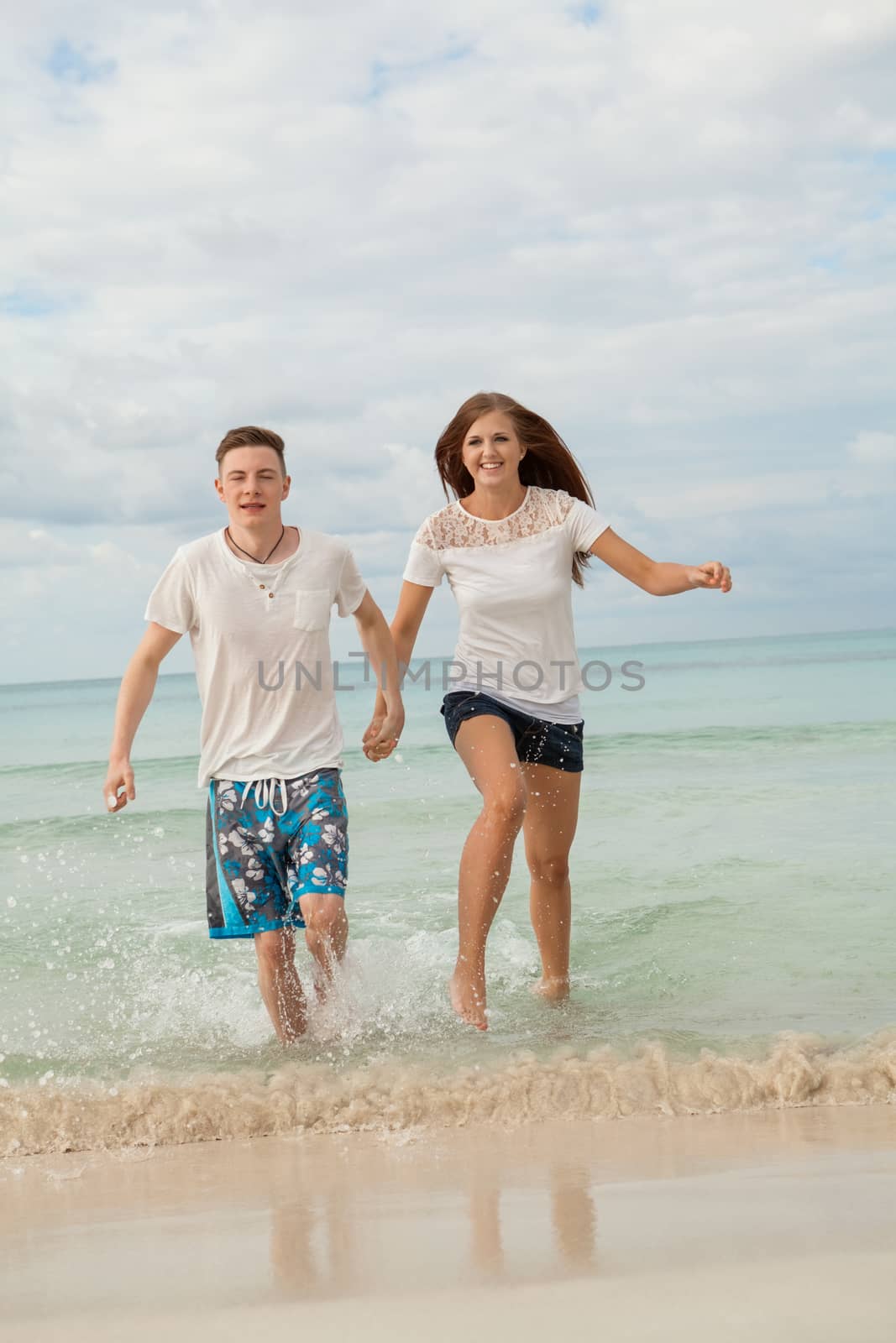 happy young couple on the beach in summer holiday love togetherness