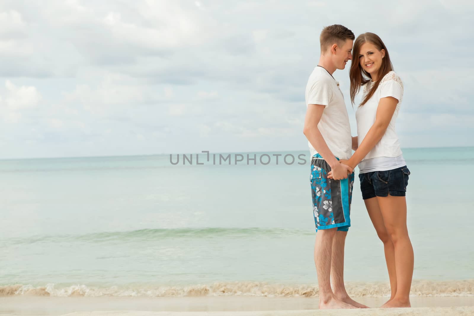 happy young couple on the beach in summer holiday love togetherness