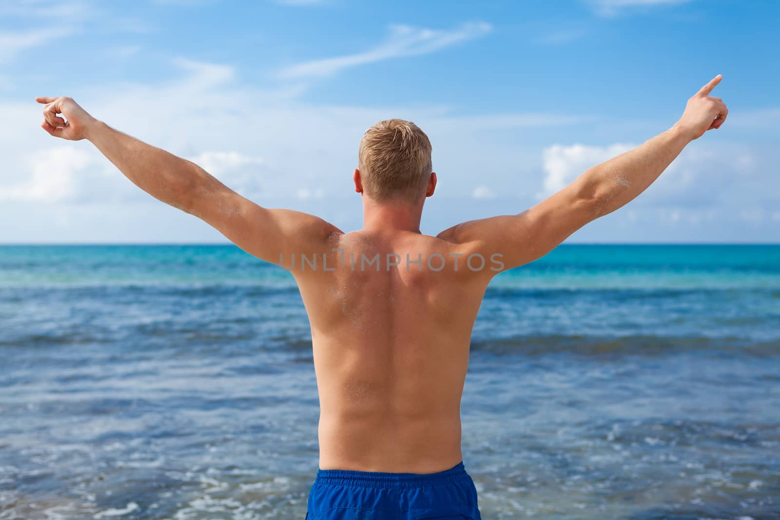 attractive young athletic man on the beach in summer outdoor vacation