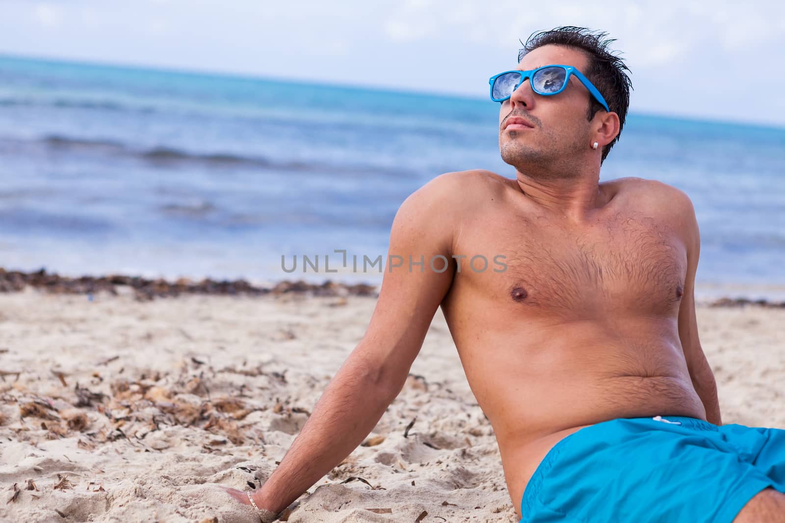 attractive young athletic man on the beach by juniart