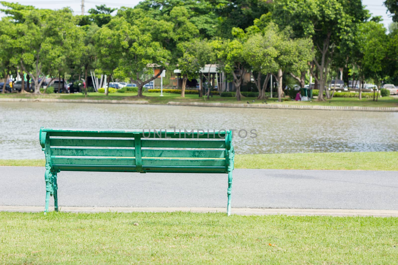 bench in park by a pond in the background, thailand
