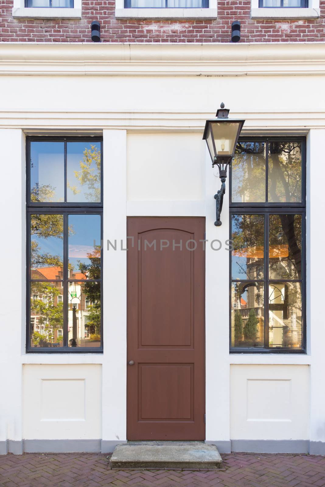 Vintage door and window in front of the house with classic lamp beside