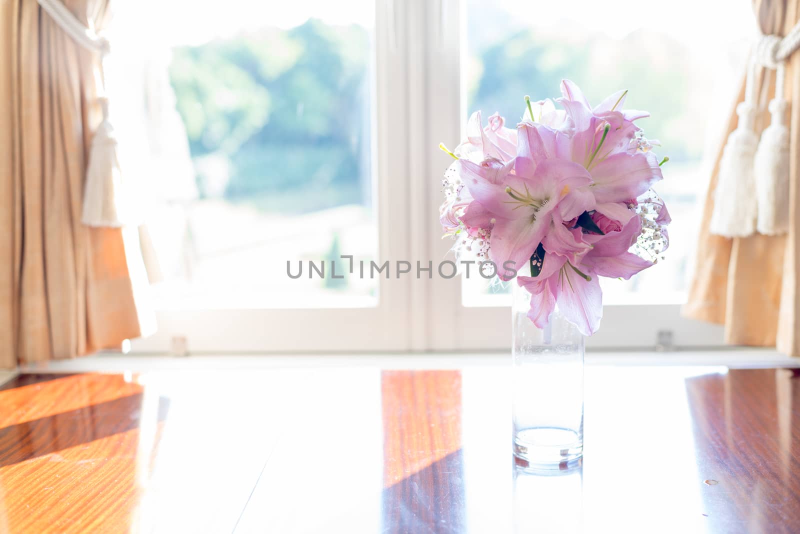 Pink Lily flower in glass jar placed by the elegant look window vintage style