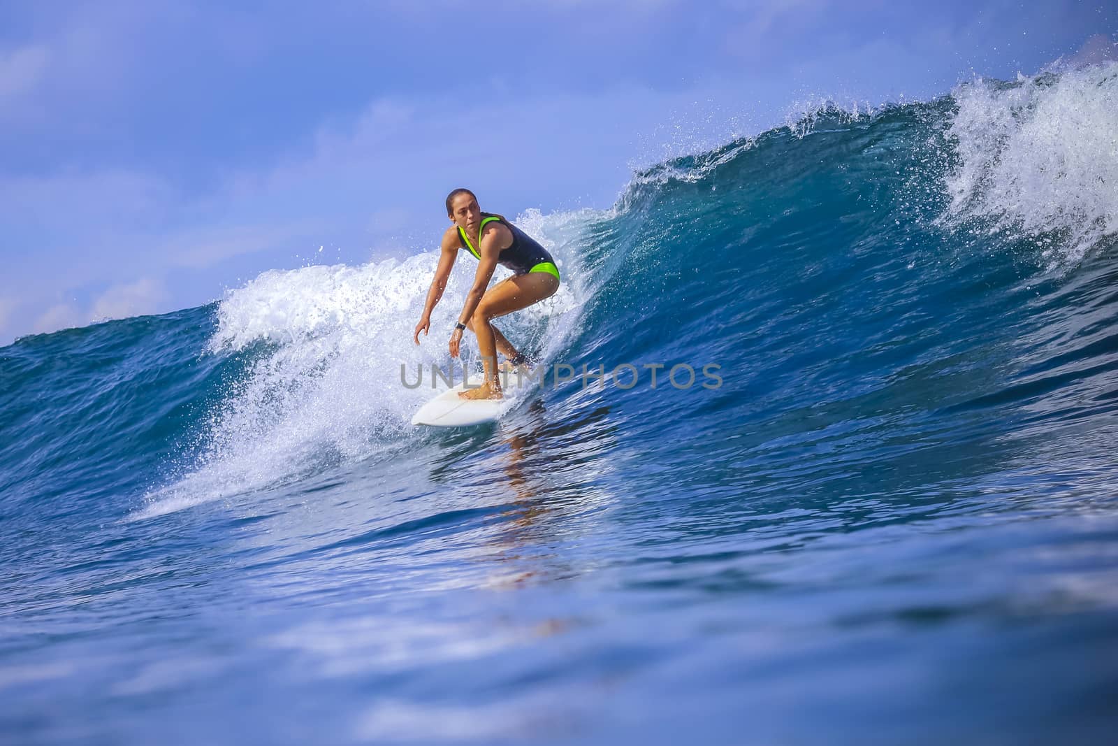 Surfer girl on Amazing Blue Wave, Bali island.