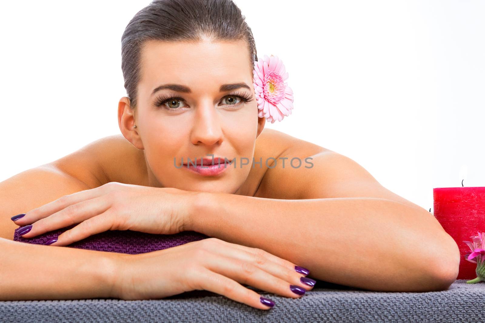 Beautiful woman enjoying a hot stone massage treatment in a spa with a line of smooth heated black basalt stones on her spine to relax her muscles