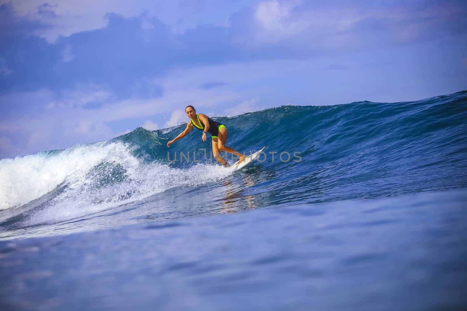 Surfer girl on Amazing Blue Wave, Bali island.