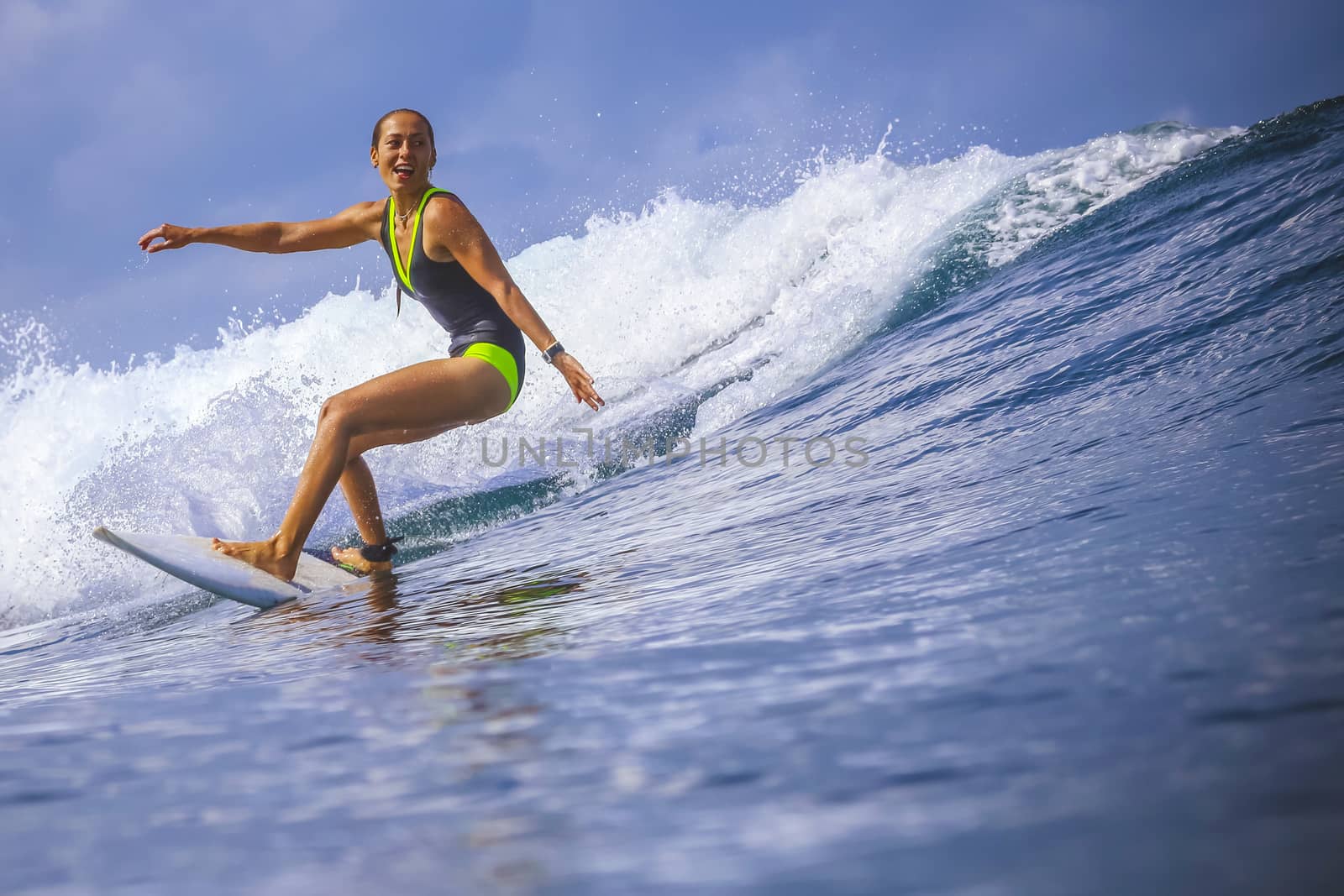 Surfer girl on Amazing Blue Wave, Bali island.