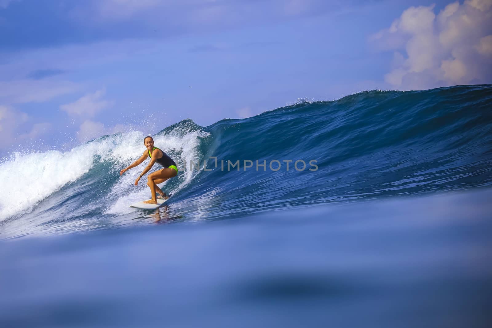 Surfer girl on Amazing Blue Wave, Bali island.