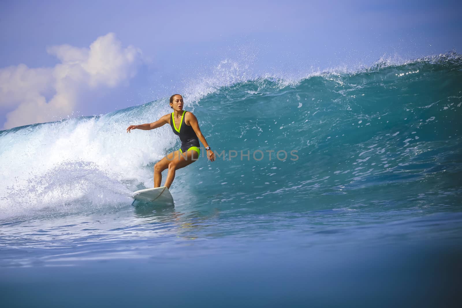 Surfer girl on Amazing Blue Wave, Bali island.