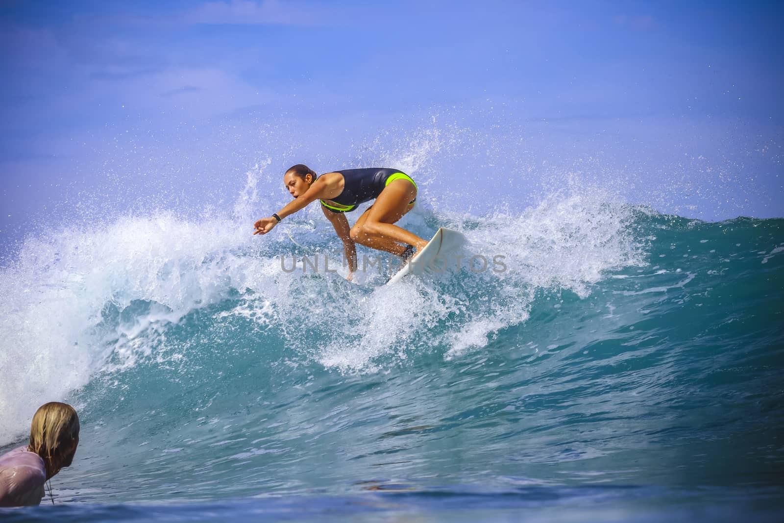 Surfer girl on Amazing Blue Wave, Bali island.