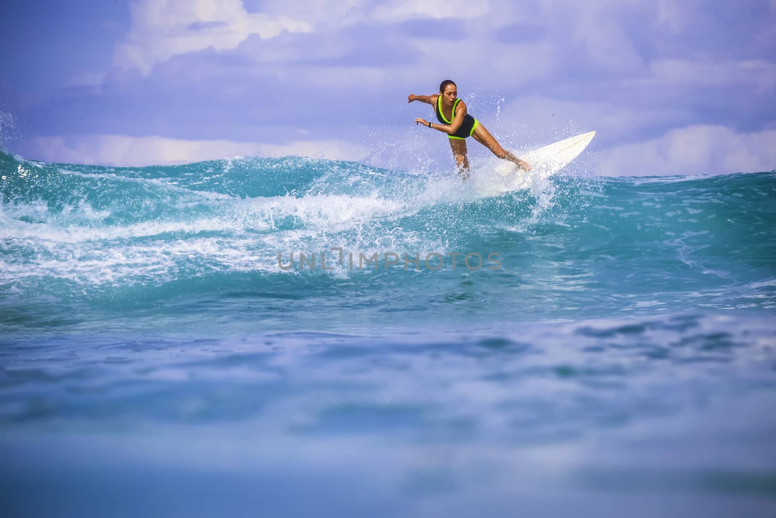 Surfer girl on Amazing Blue Wave, Bali island.