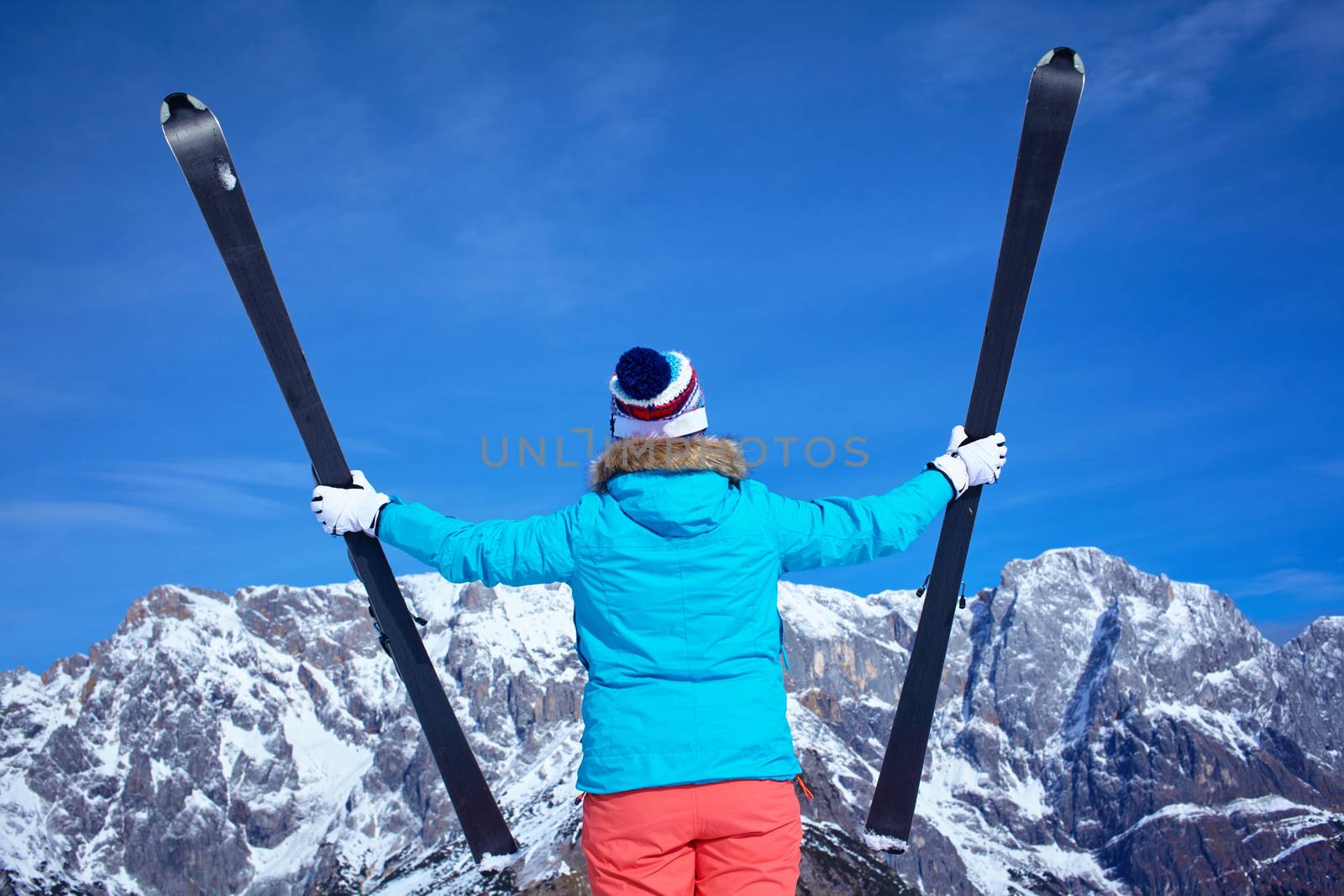 Ski, winter, snow, skiers, sun and fun - Back view of Middle Aged Woman On Ski Holiday In Mountains
