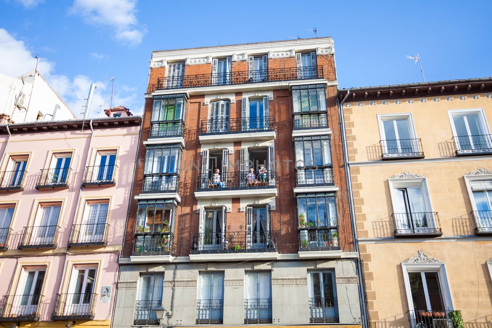 Madrid, Spain - May 6, 2012: Young girls on balconies of a typical building facade on a street of Madrid, Spain
