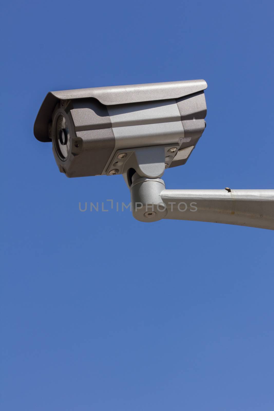 CCTV security camera, blue sky background.