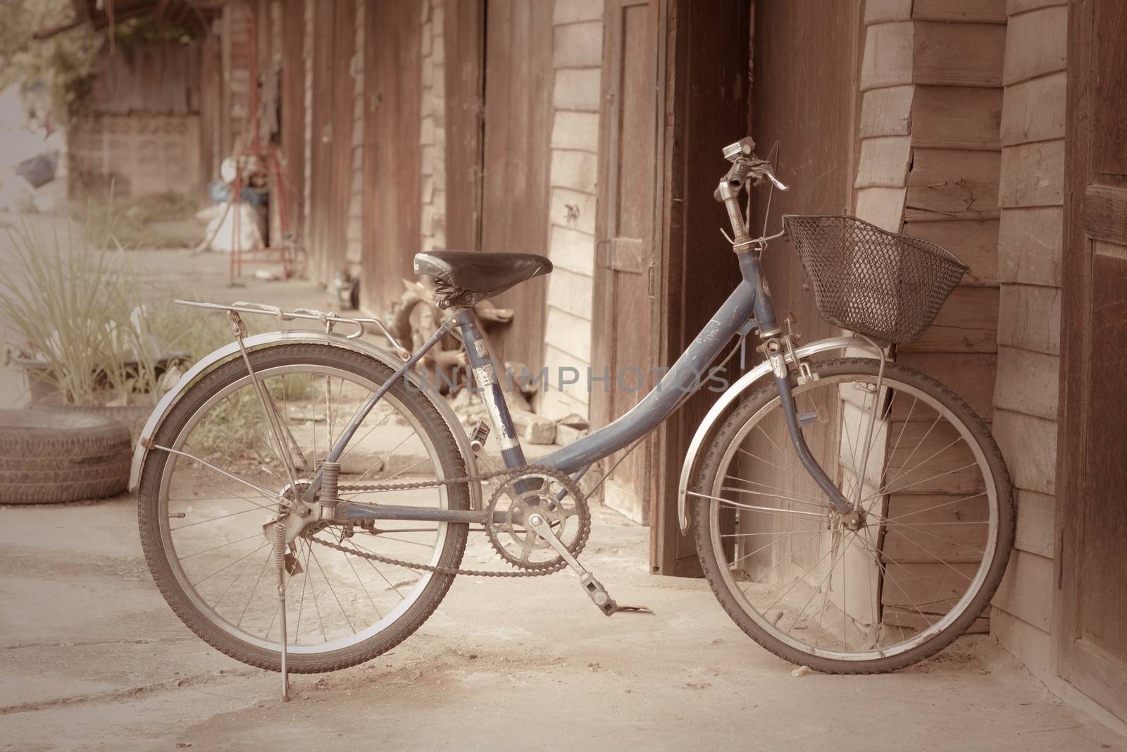 Old bike in front of the wooden wall at home.