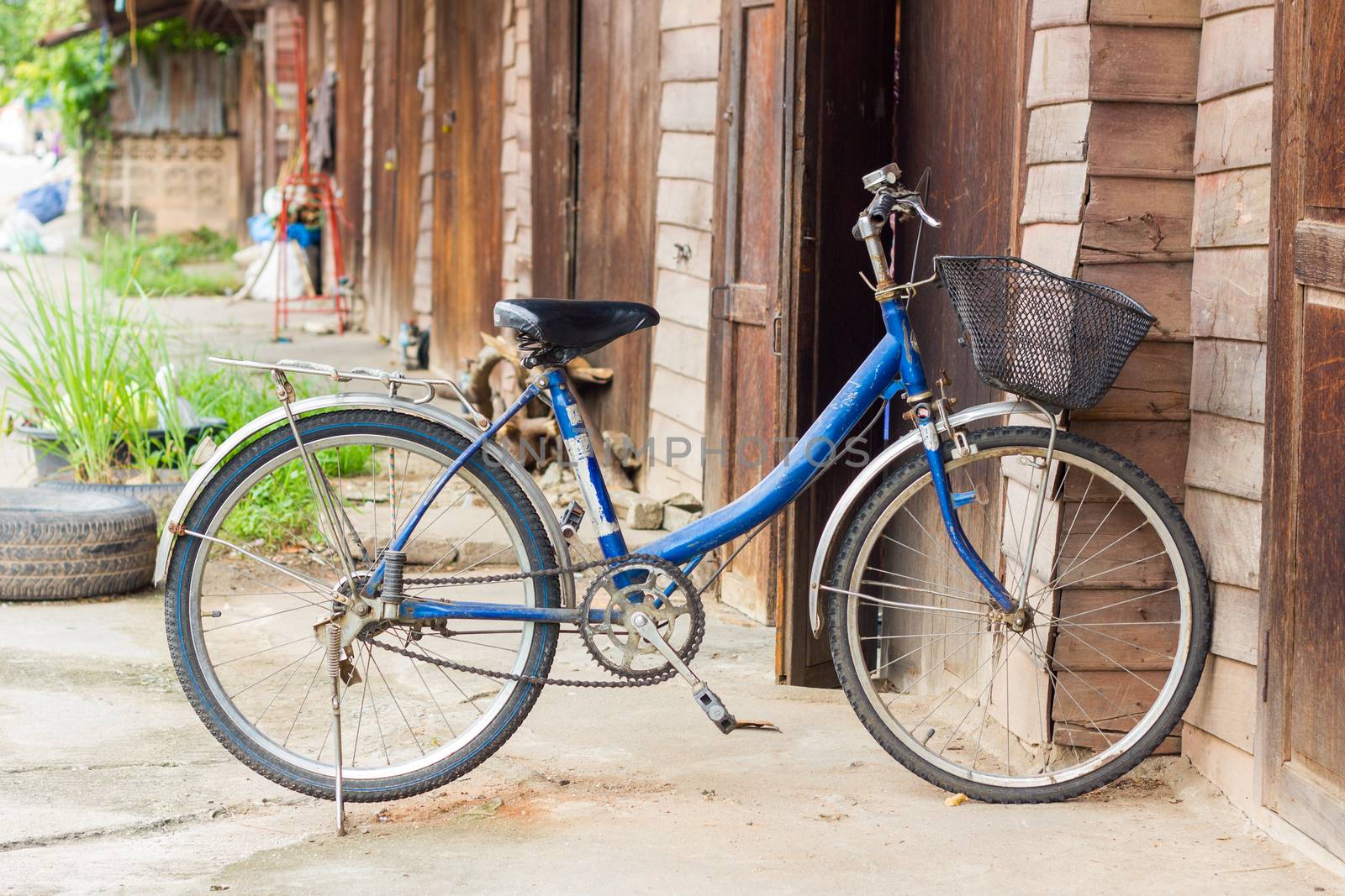 Old bike in front of the wooden wall at home.