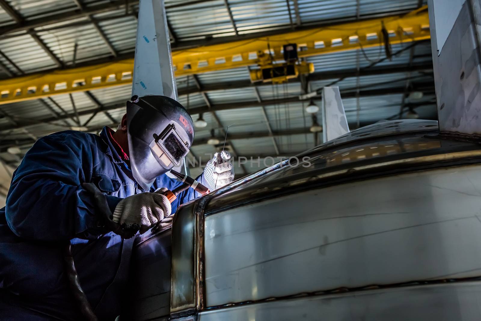 Man welding with reflection of sparks on visor. Hard job.  by sarymsakov