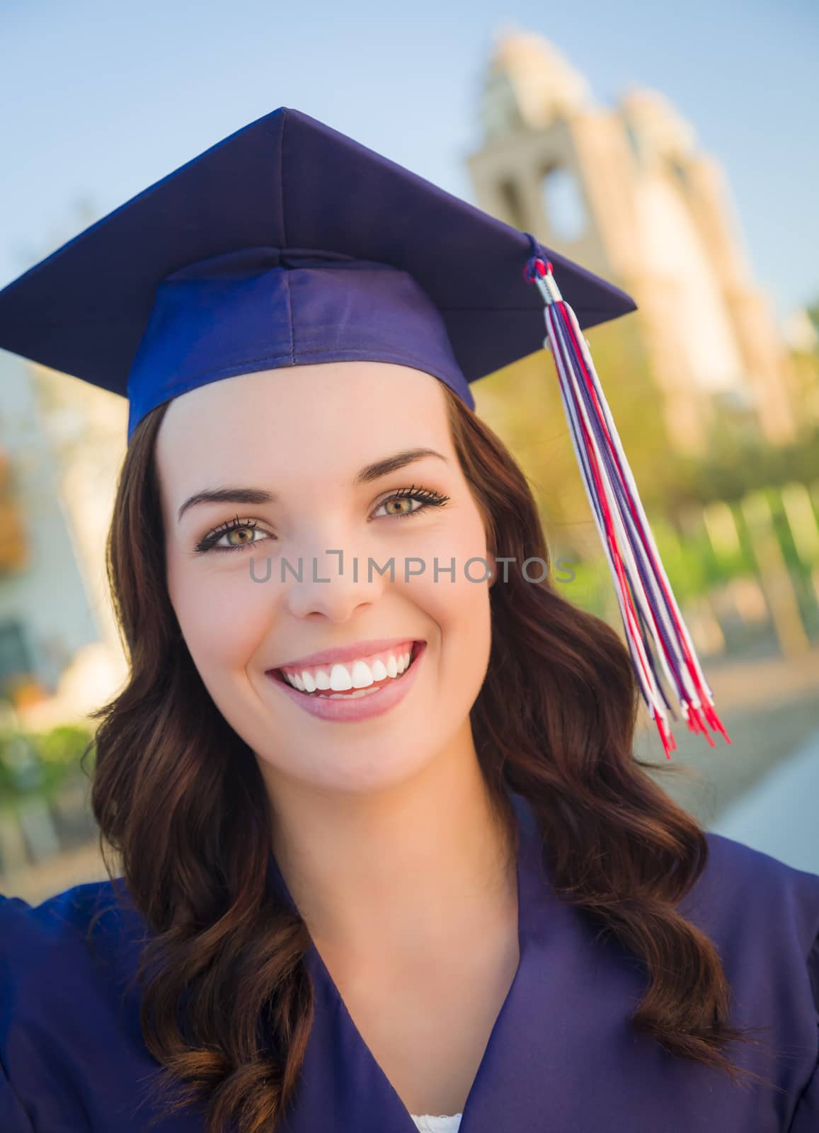 Happy Graduating Mixed Race Woman In Cap and Gown Celebrating on Campus.