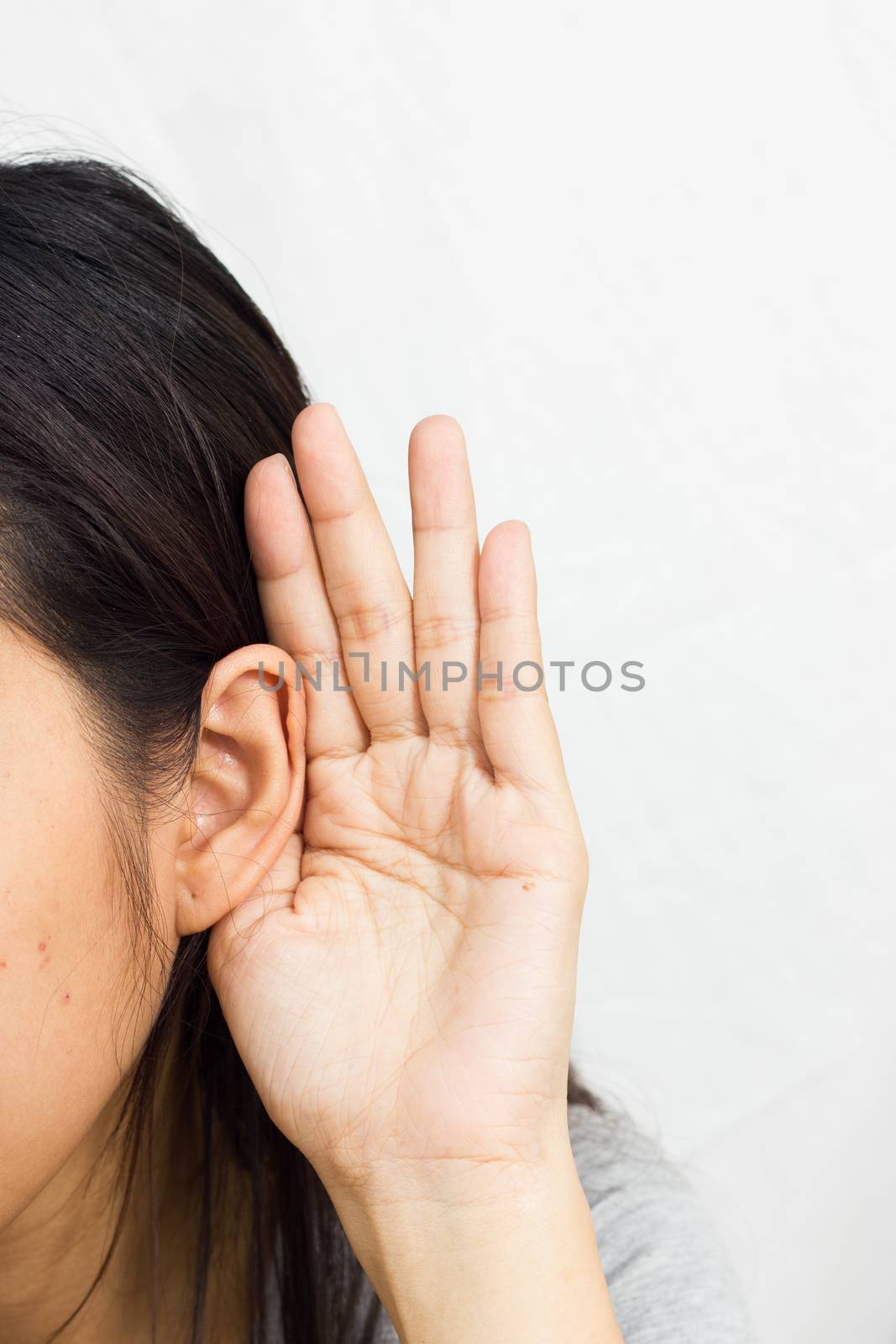 woman holds his hand near his ear and listening by a3701027