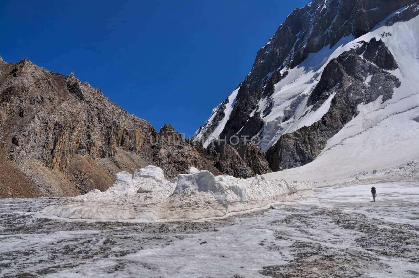 Glacier below snow-covered highest peaks in Tien-Shan mountain range in Kyrgyzstan