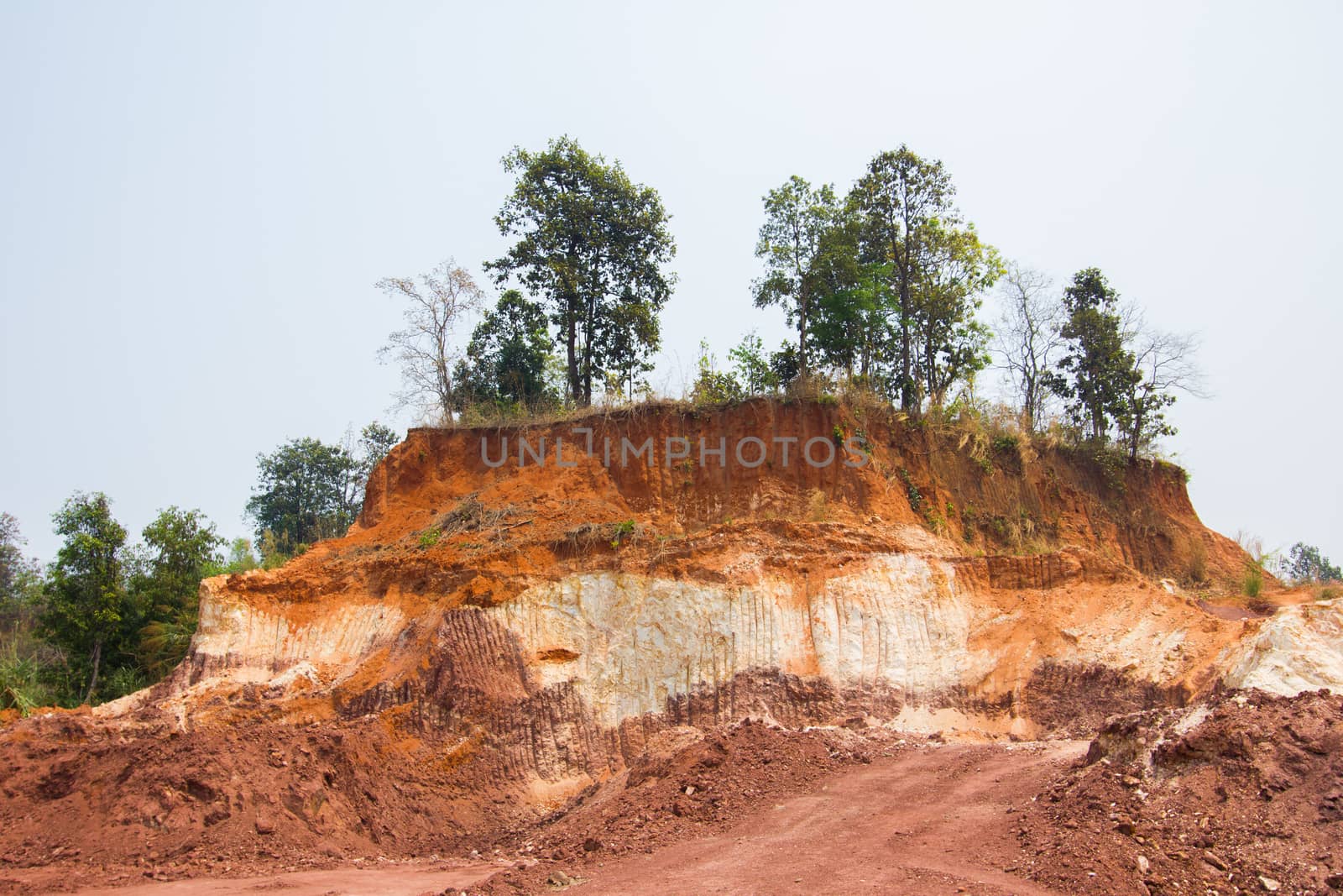 Layer of soil Front loader strips all side of a hill.