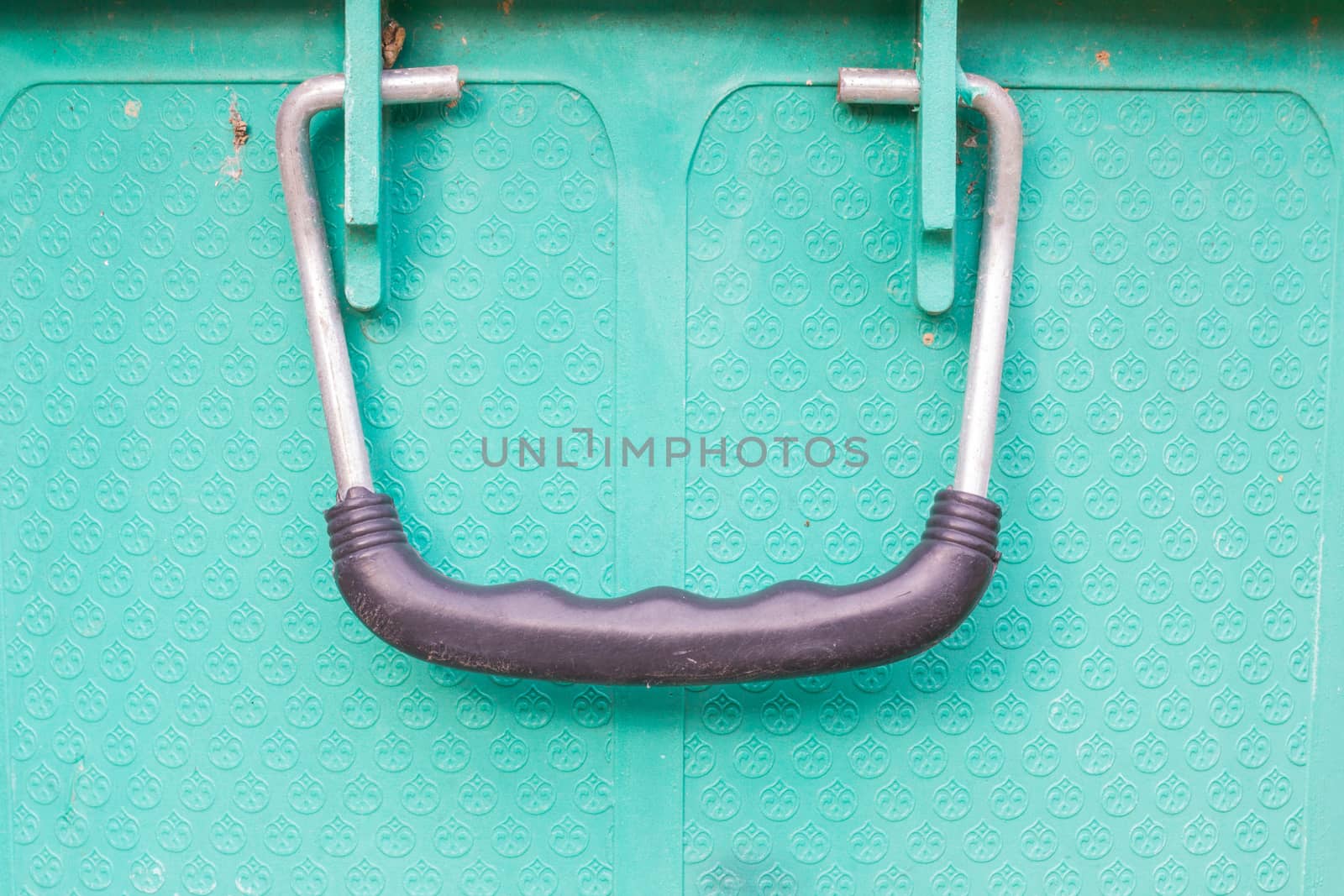 old black handle of green bucket, closeup.