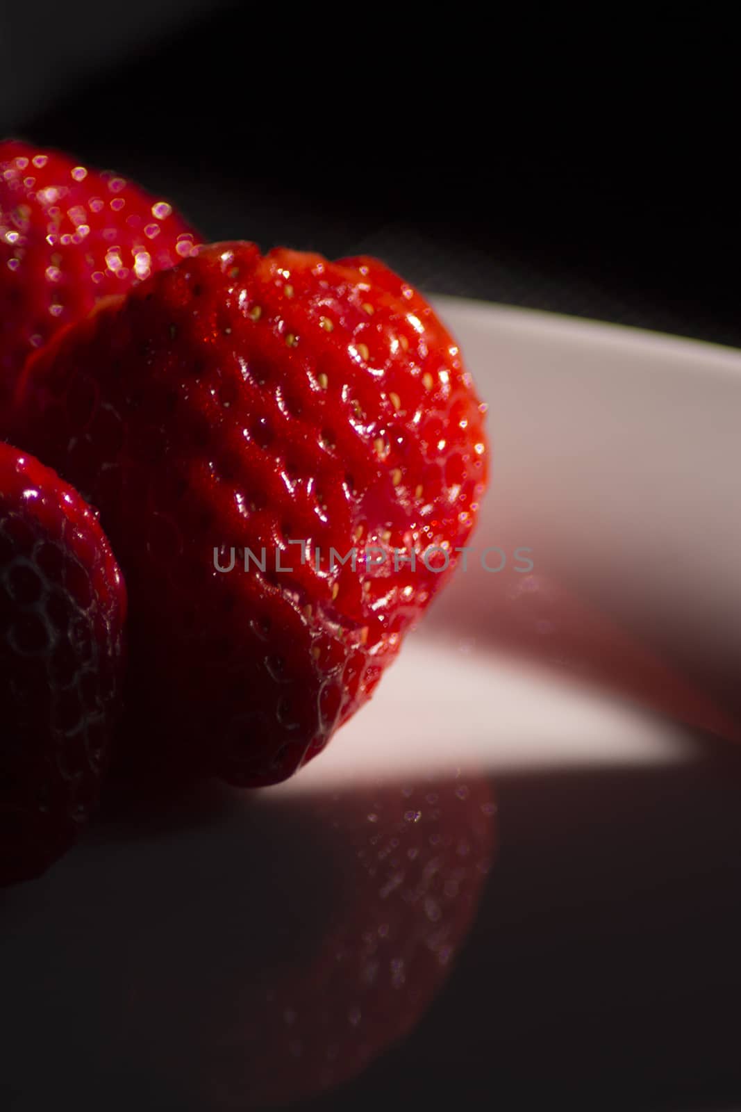 Strawberries on black background. Bright deep red.