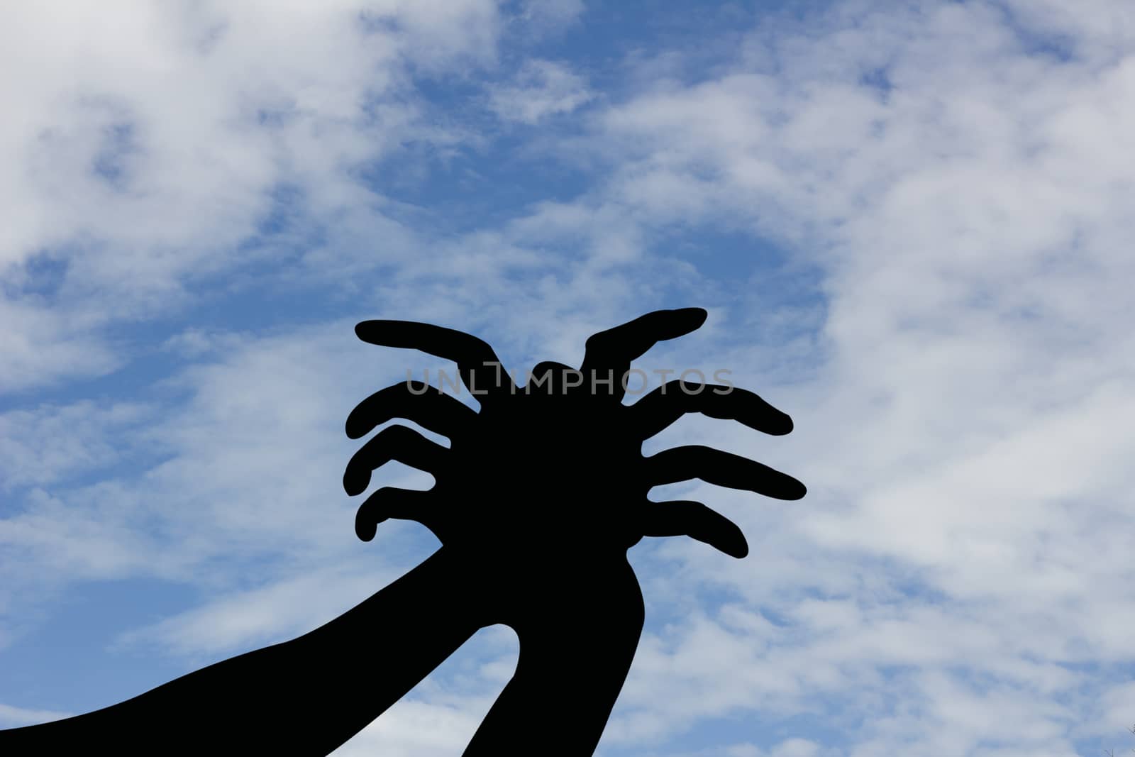 spider shape hand silhouette in blue sky.