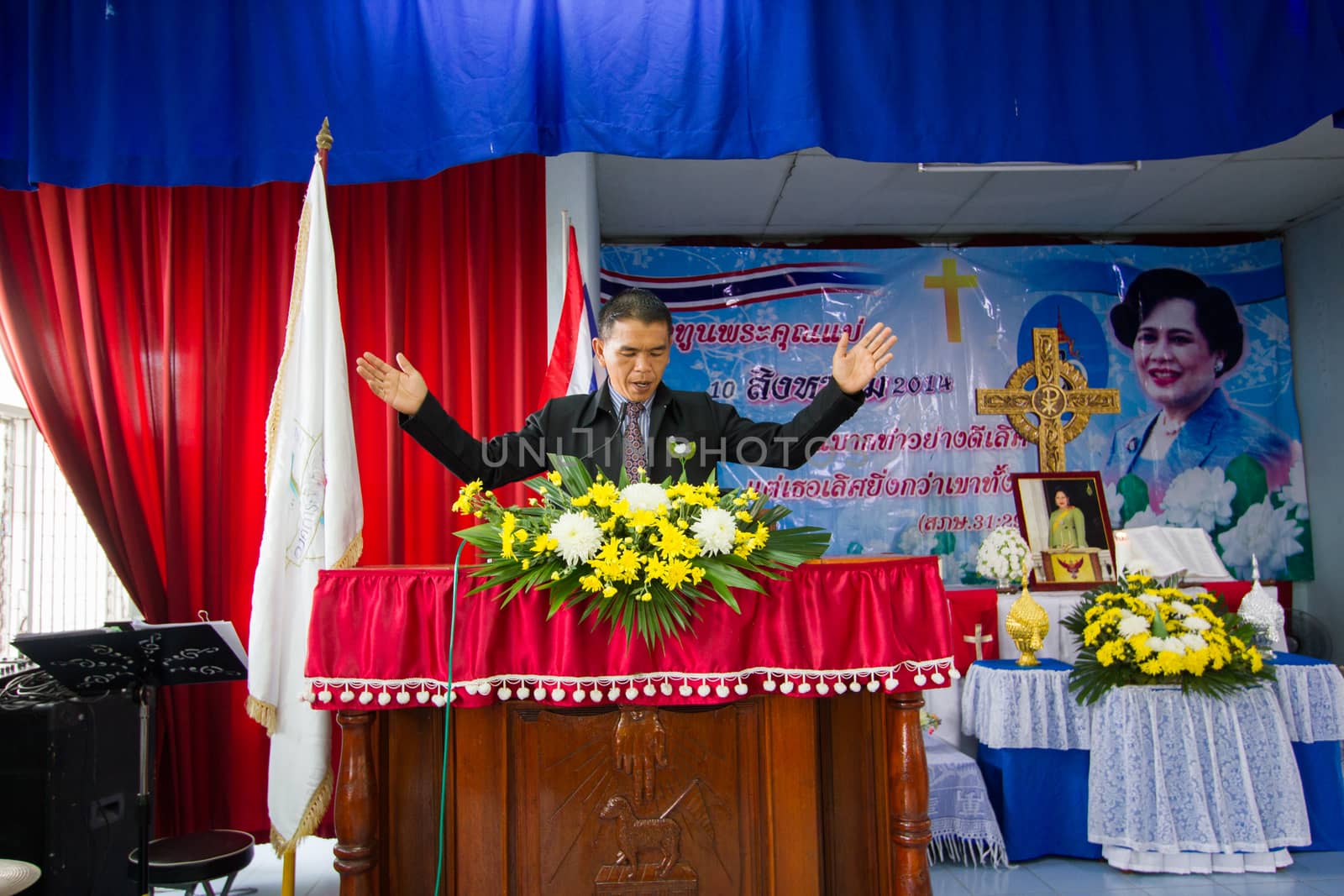 CHIANGRAI, THAILAND - AUG 10: unidentified man on pulpit praying for Her Majesty Queen Sirikit in church on August 10, 2014 in Chiangrai, Thailand. Thai people in every religions always pray for the Queen in the occation of Her Mejesty Queen's Birthday (on August, 12)