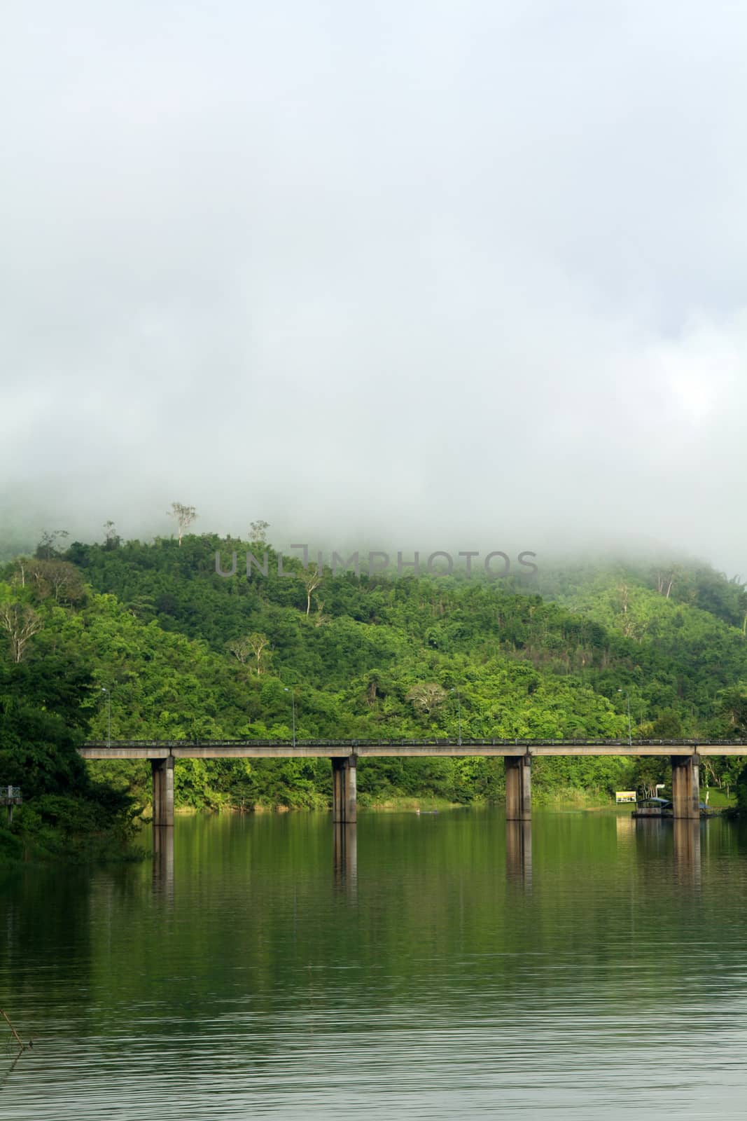 Bridge across river with mountain and fog