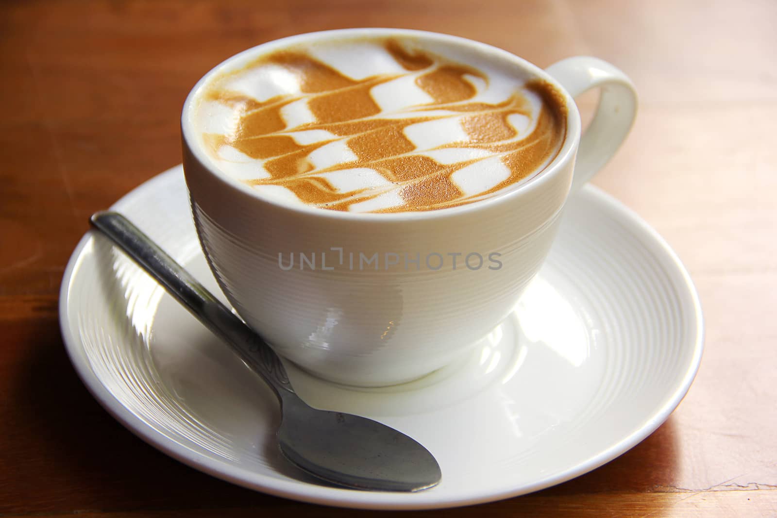 Cup of latte coffee on the wooden desk