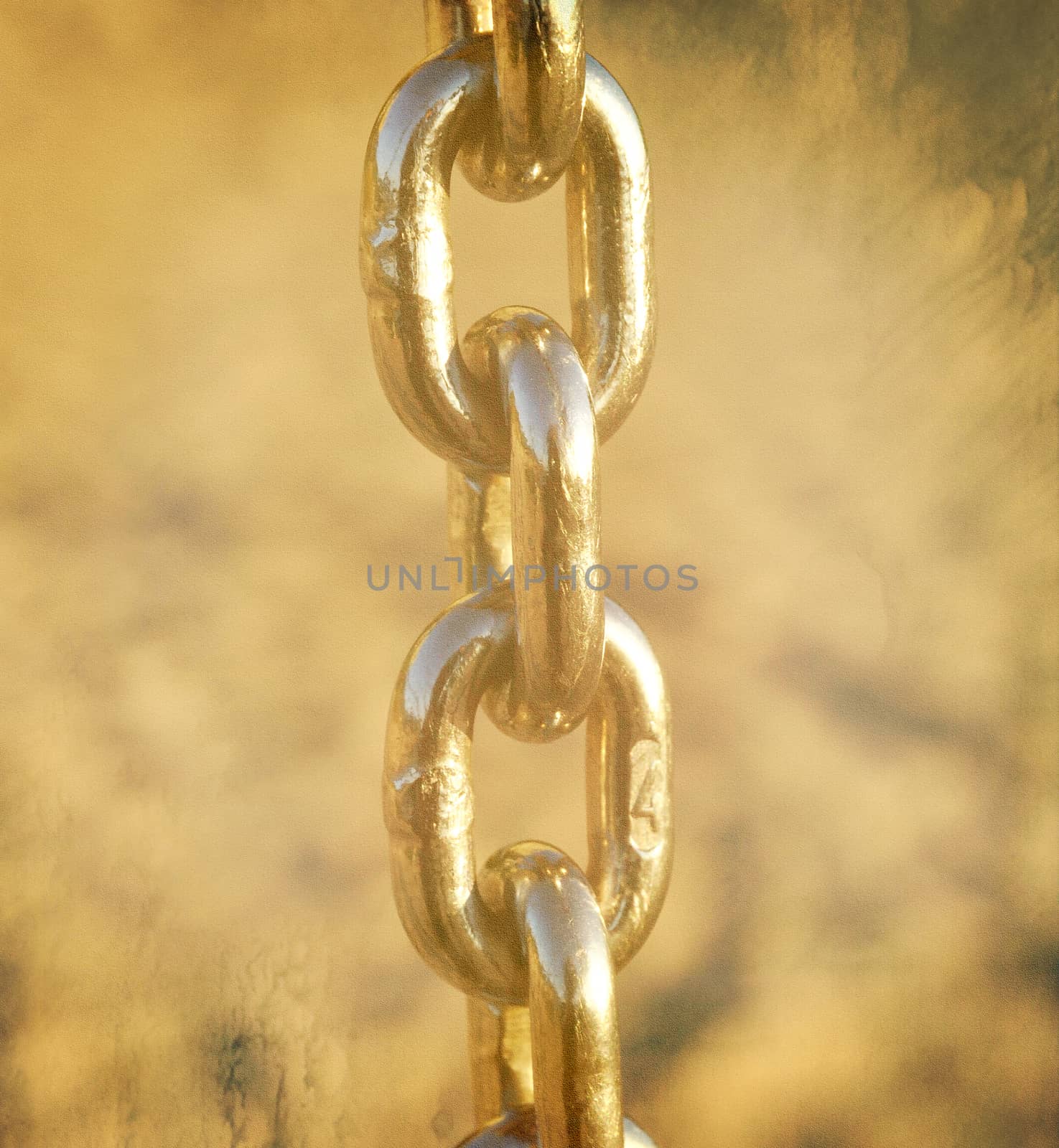 Textured closeup of a golden chain in soft light, 