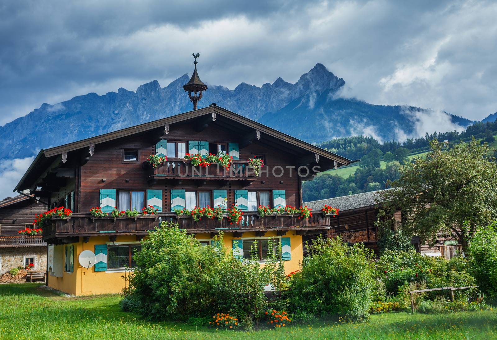Traditional Austrian house. Summer landscape in Alps.
