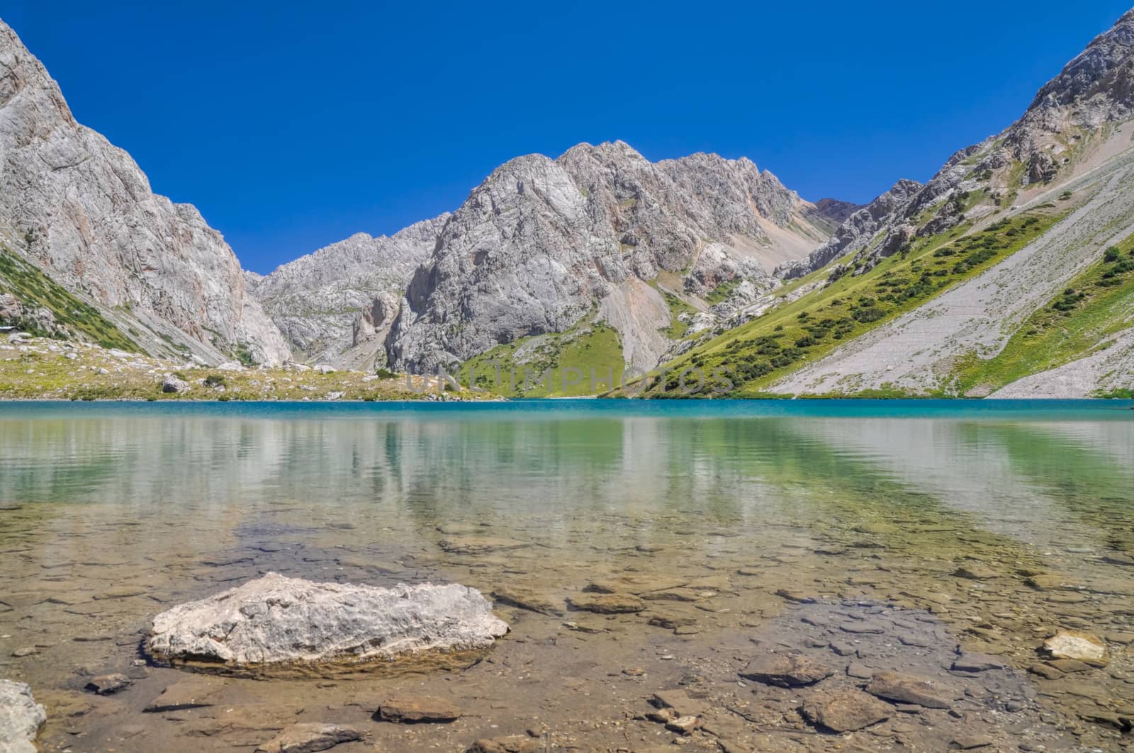 Crystal clear lake in mountain range Tien-Shan in Kyrgyzstan