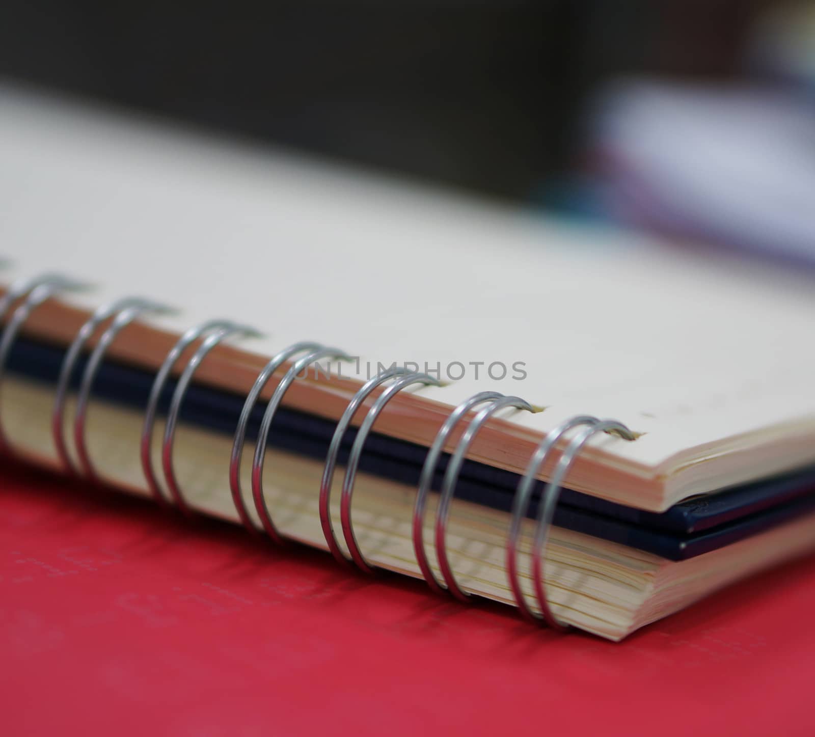 Spiral memory notebook was placed on a table at office.                             