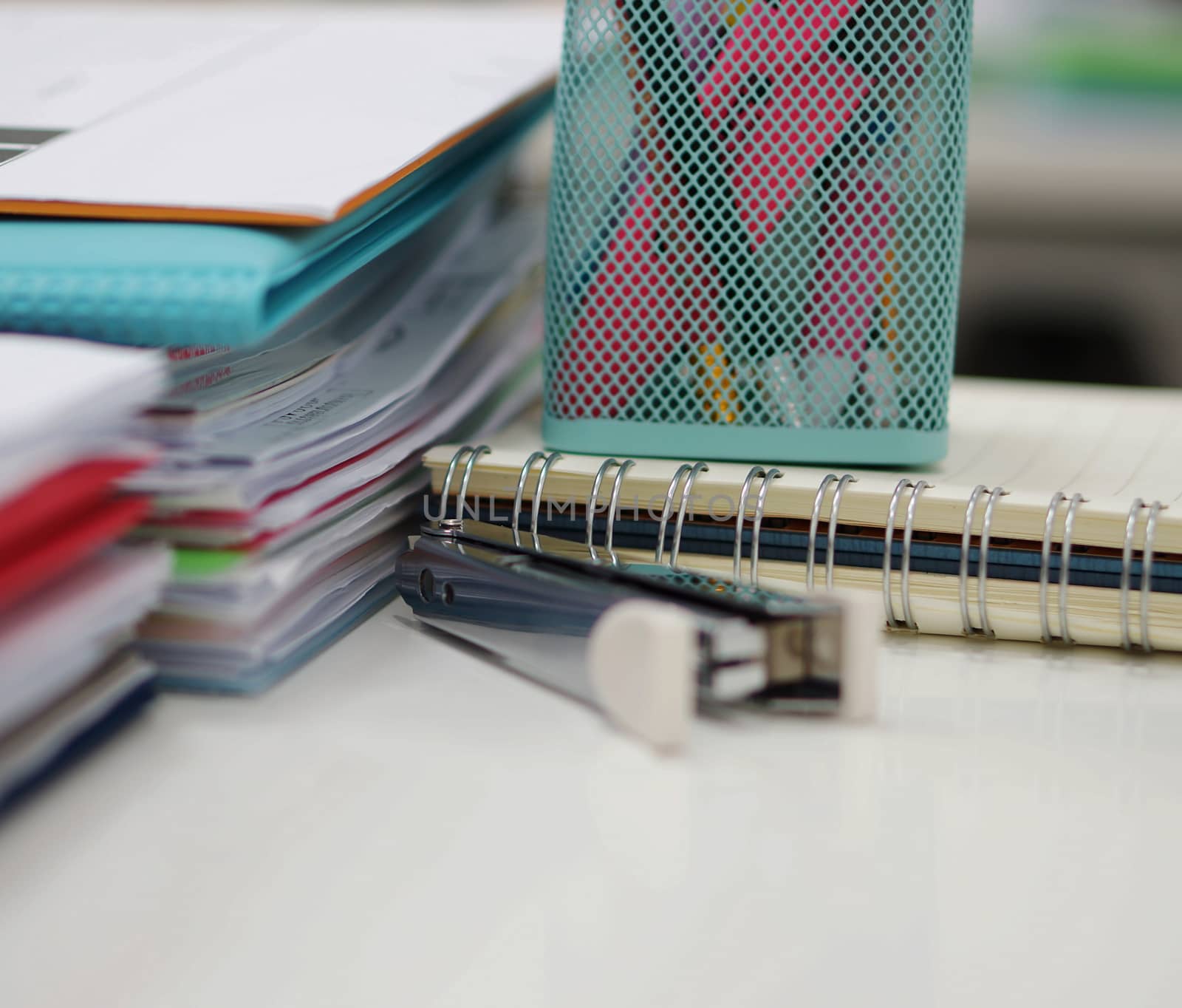 Documents, folders, staples and some of the office supplies was placed on the desk.                               