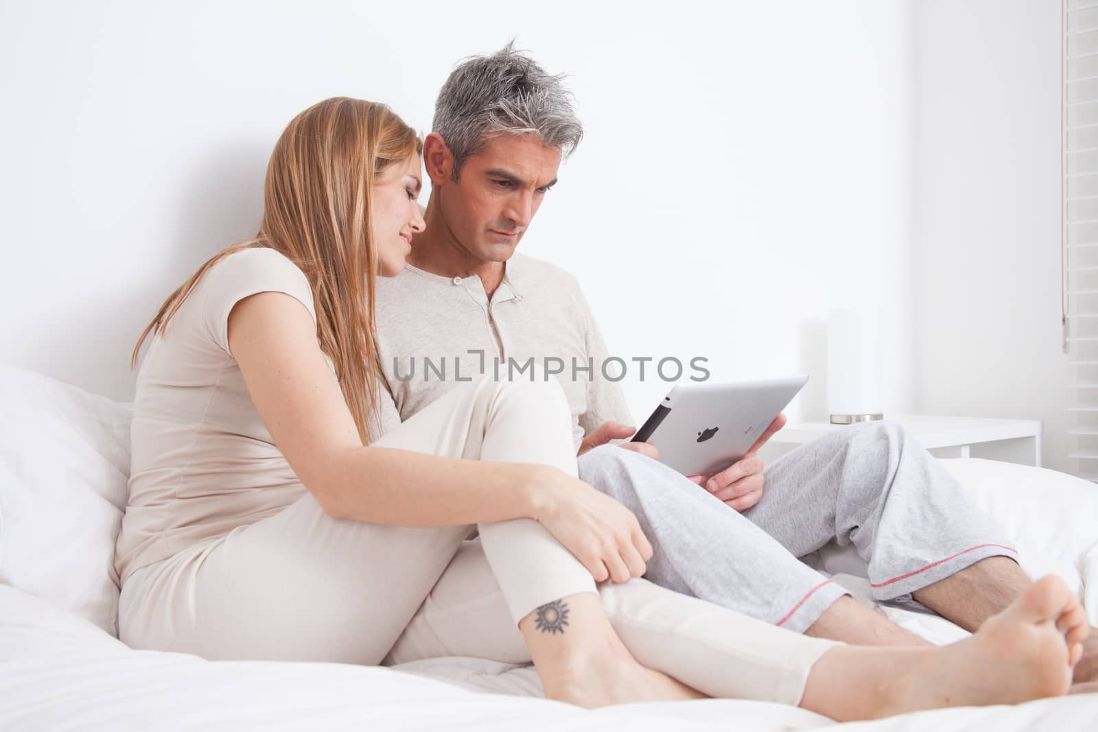 25-30, adult, apartment, attractive, bed, bedroom, caucasian, Couple, fun, handsome, happy, home, horizontal, house, leisure, lifestyle, love, marriage, men, model, nightwear, old, pc, people, person, property, releases, sitting, smile, tablet, two, women, years, young