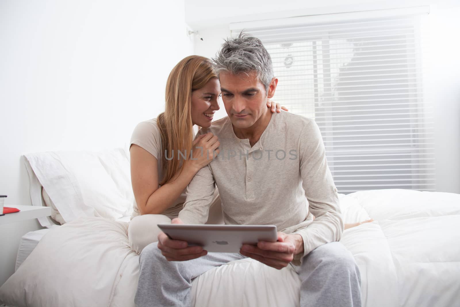 25-30, adult, apartment, attractive, bed, bedroom, caucasian, Couple, fun, handsome, happy, home, horizontal, house, leisure, lifestyle, love, marriage, men, model, nightwear, old, pc, people, person, property, releases, sitting, smile, tablet, two, women, years, young