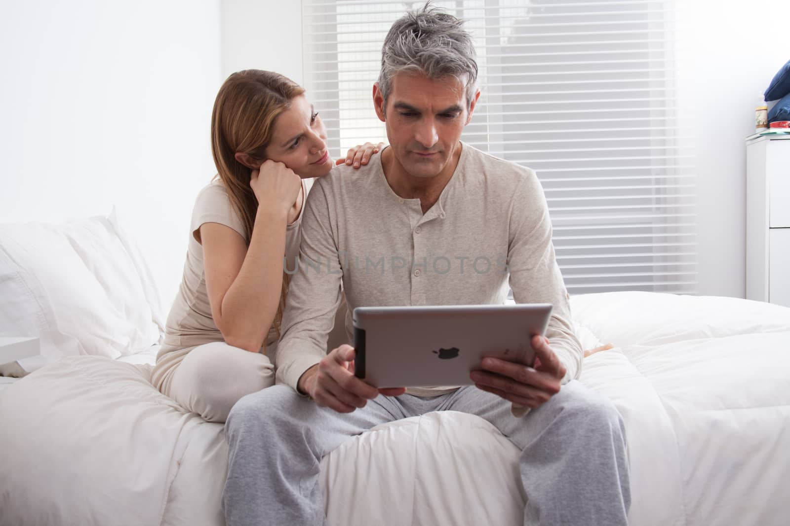 25-30, adult, apartment, attractive, bed, bedroom, caucasian, Couple, fun, handsome, happy, home, horizontal, house, leisure, lifestyle, love, marriage, men, model, nightwear, old, pc, people, person, property, releases, sitting, smile, tablet, two, women, years, young