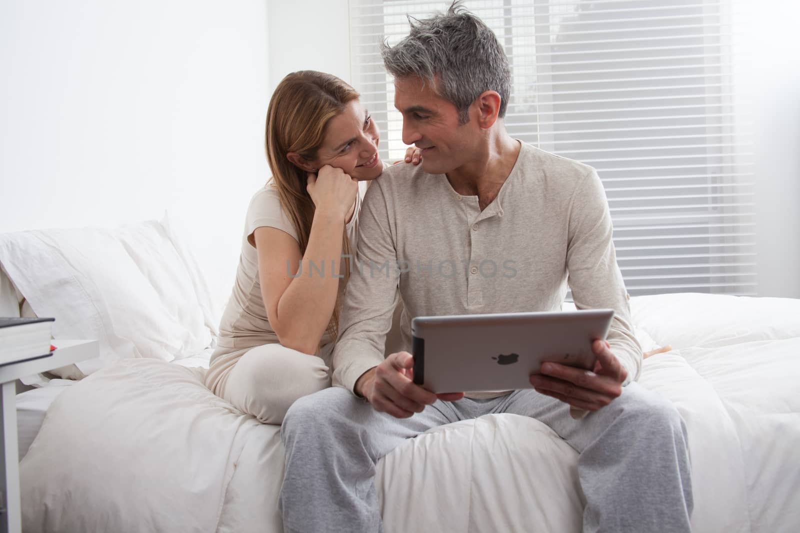 25-30, adult, apartment, attractive, bed, bedroom, caucasian, Couple, fun, handsome, happy, home, horizontal, house, leisure, lifestyle, love, marriage, men, model, nightwear, old, pc, people, person, property, releases, sitting, smile, tablet, two, women, years, young