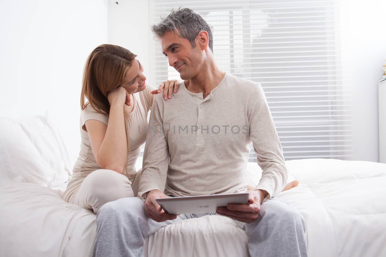 25-30, adult, apartment, attractive, bed, bedroom, caucasian, Couple, fun, handsome, happy, home, horizontal, house, leisure, lifestyle, love, marriage, men, model, nightwear, old, pc, people, person, property, releases, sitting, smile, tablet, two, women, years, young