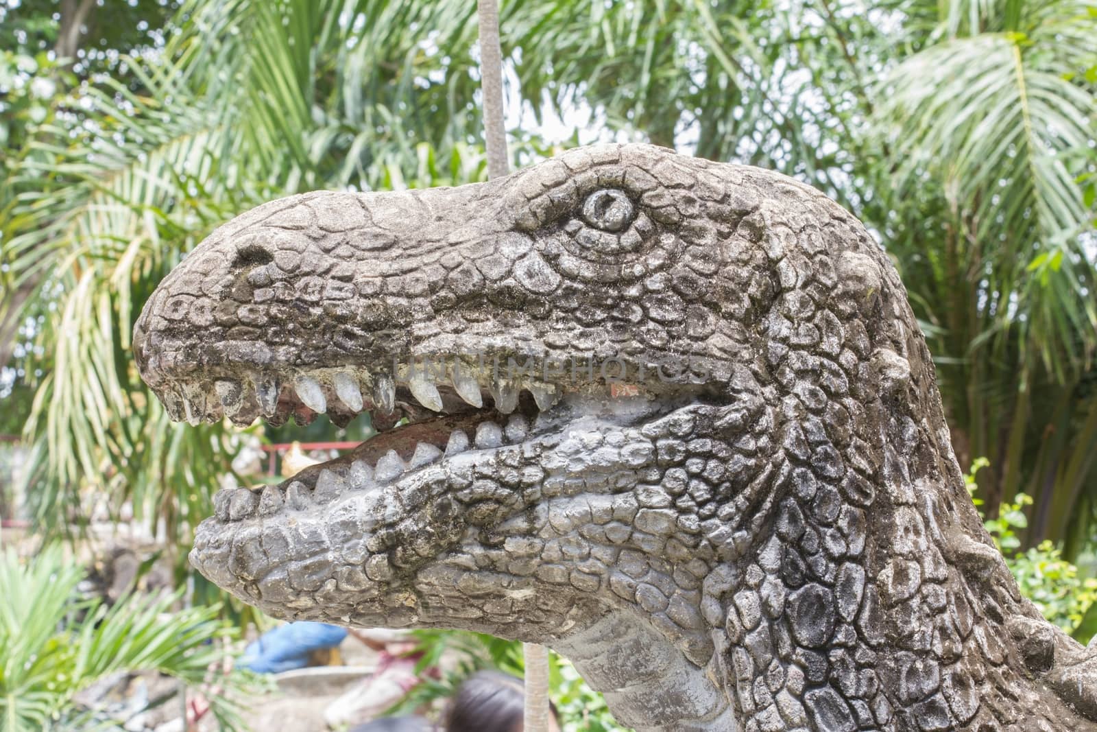 head of dinosaur sculpture in public park.