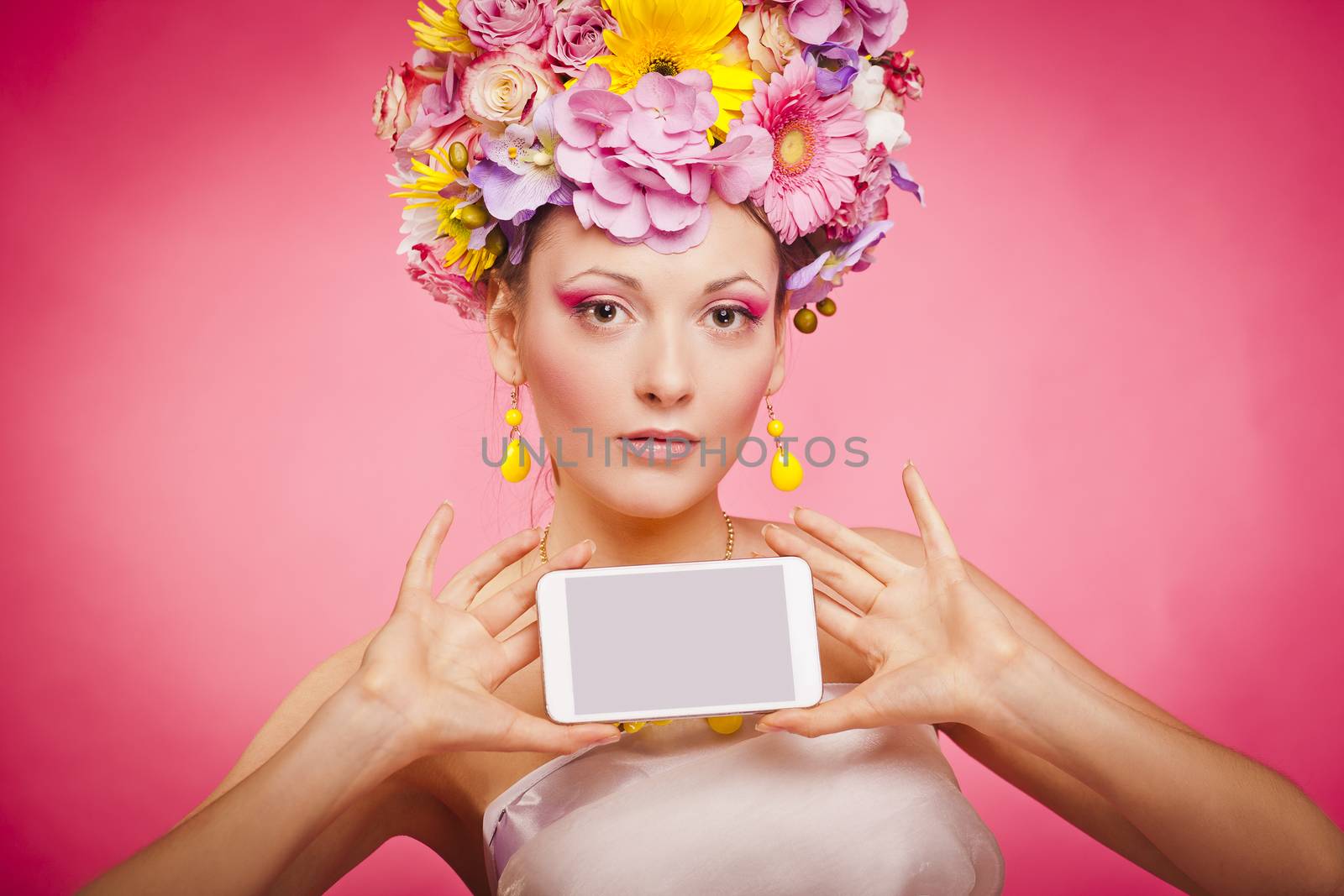 Woman showing a cell phone screen on a pink background