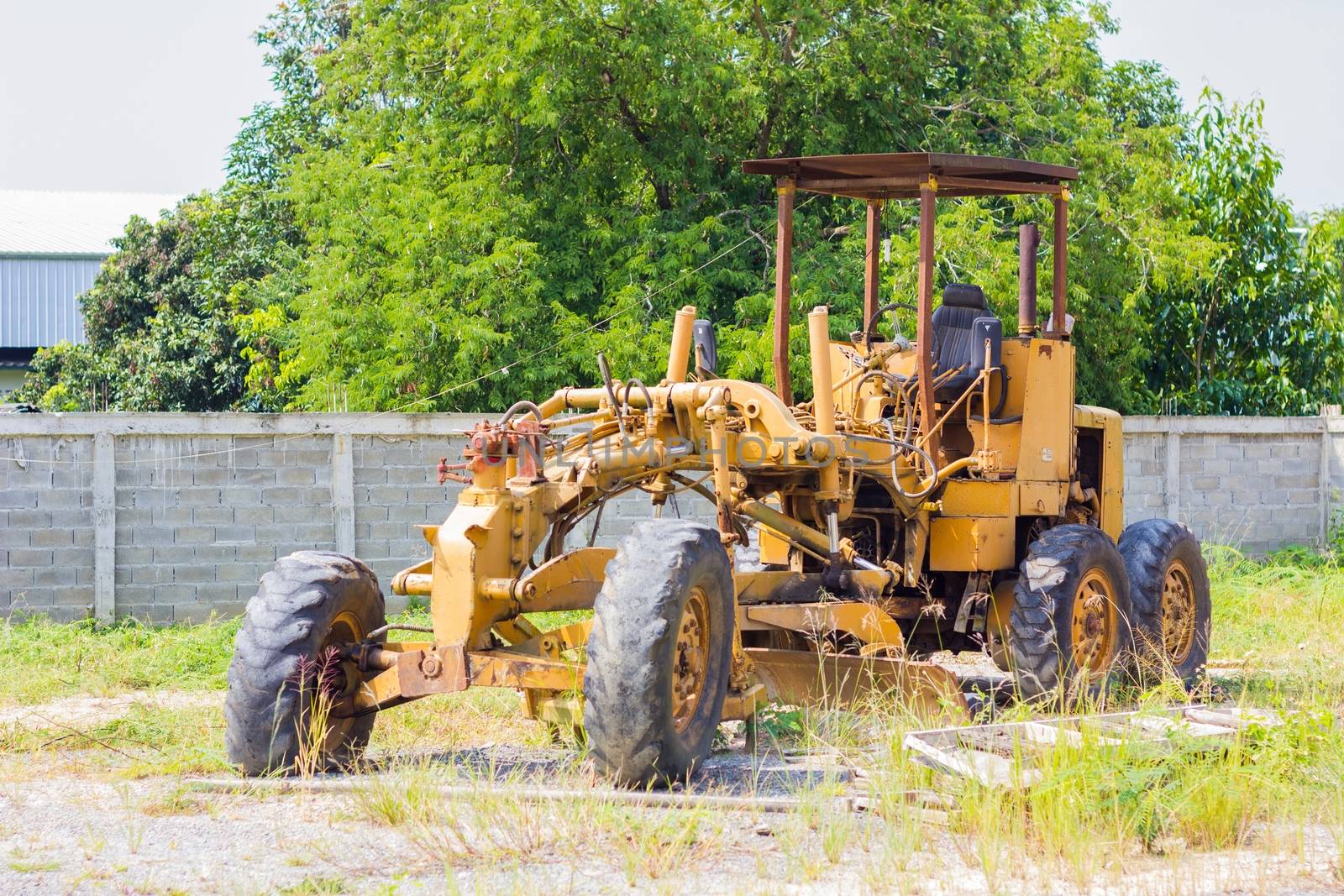 yellow abandoned  old road grader