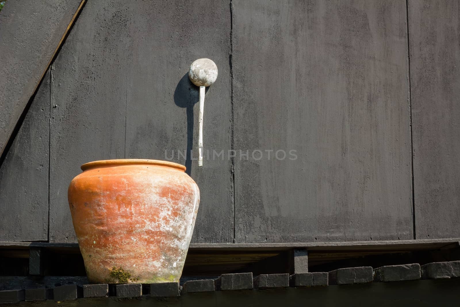 orange water jaron the black background of old wooden wall, with copyspace on the right