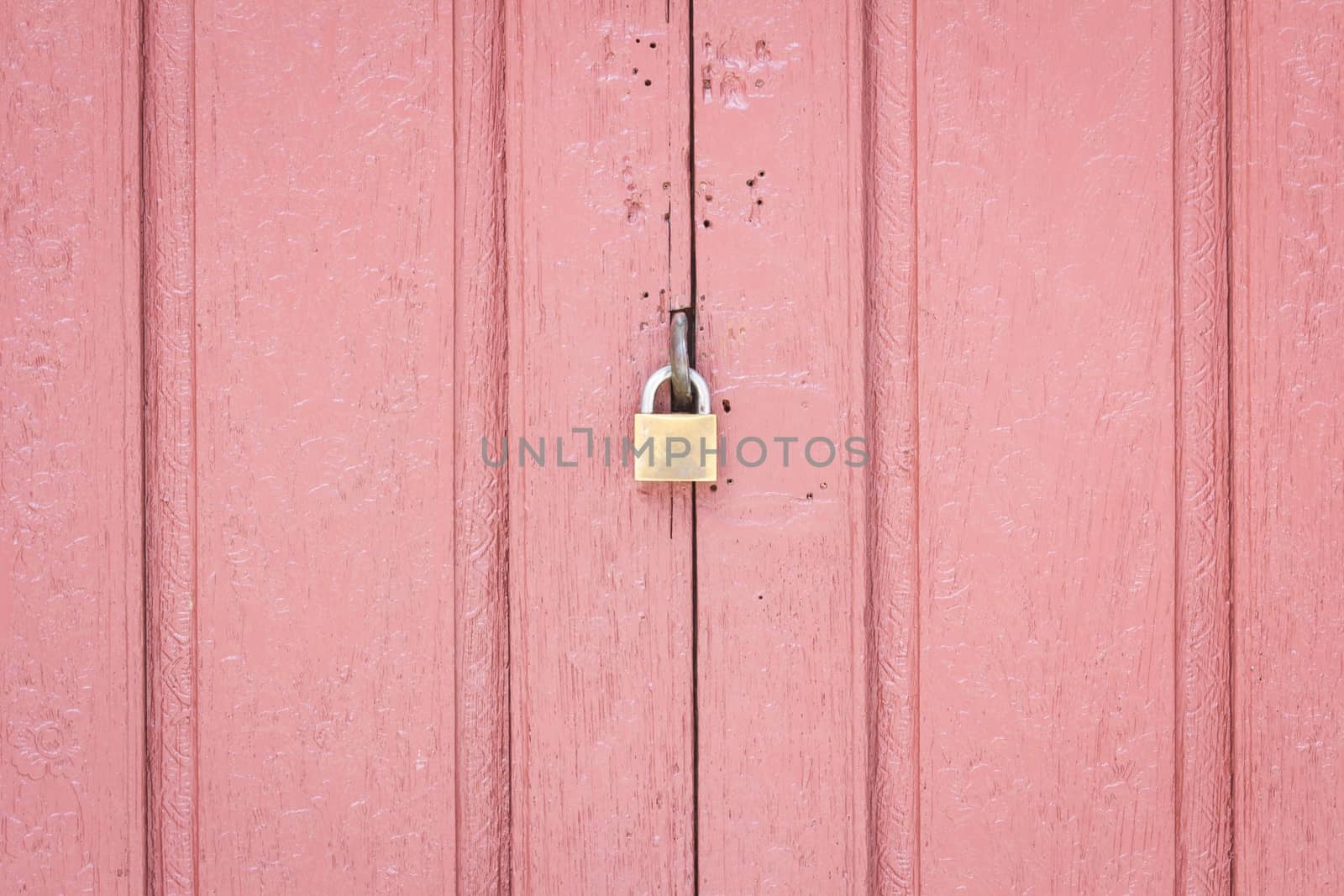 lock on the middle of pale red wood door, concept security