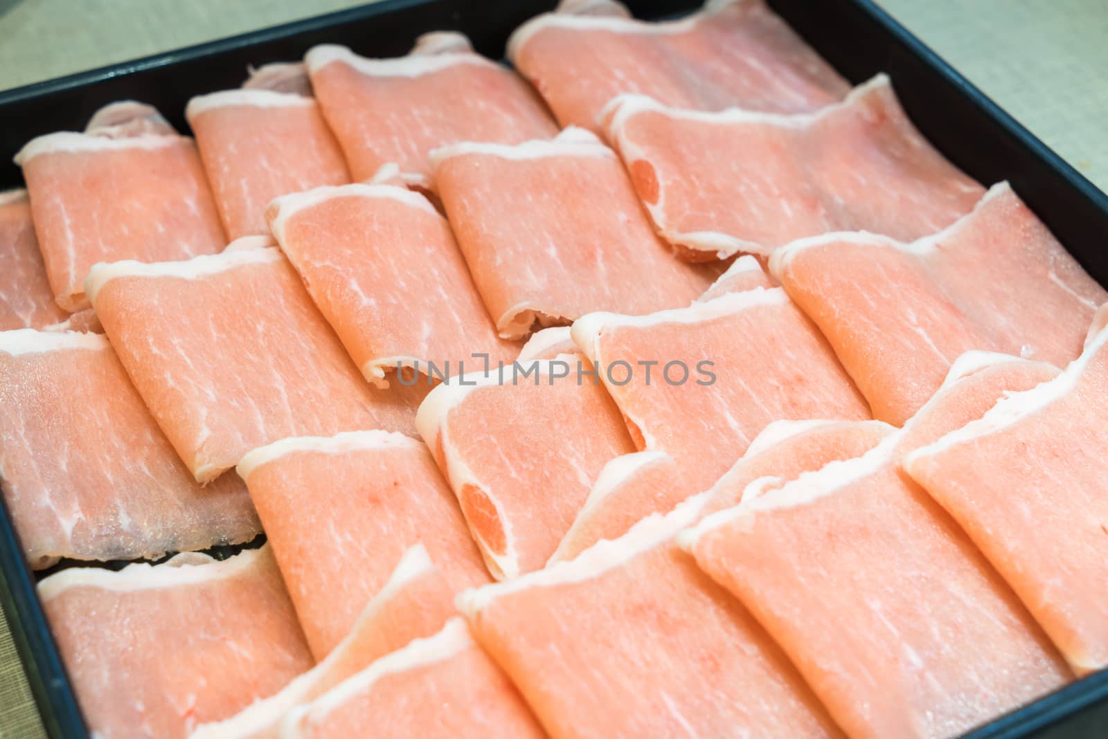 Raw pork in the dish wait to get down boiling in hot pot shabu