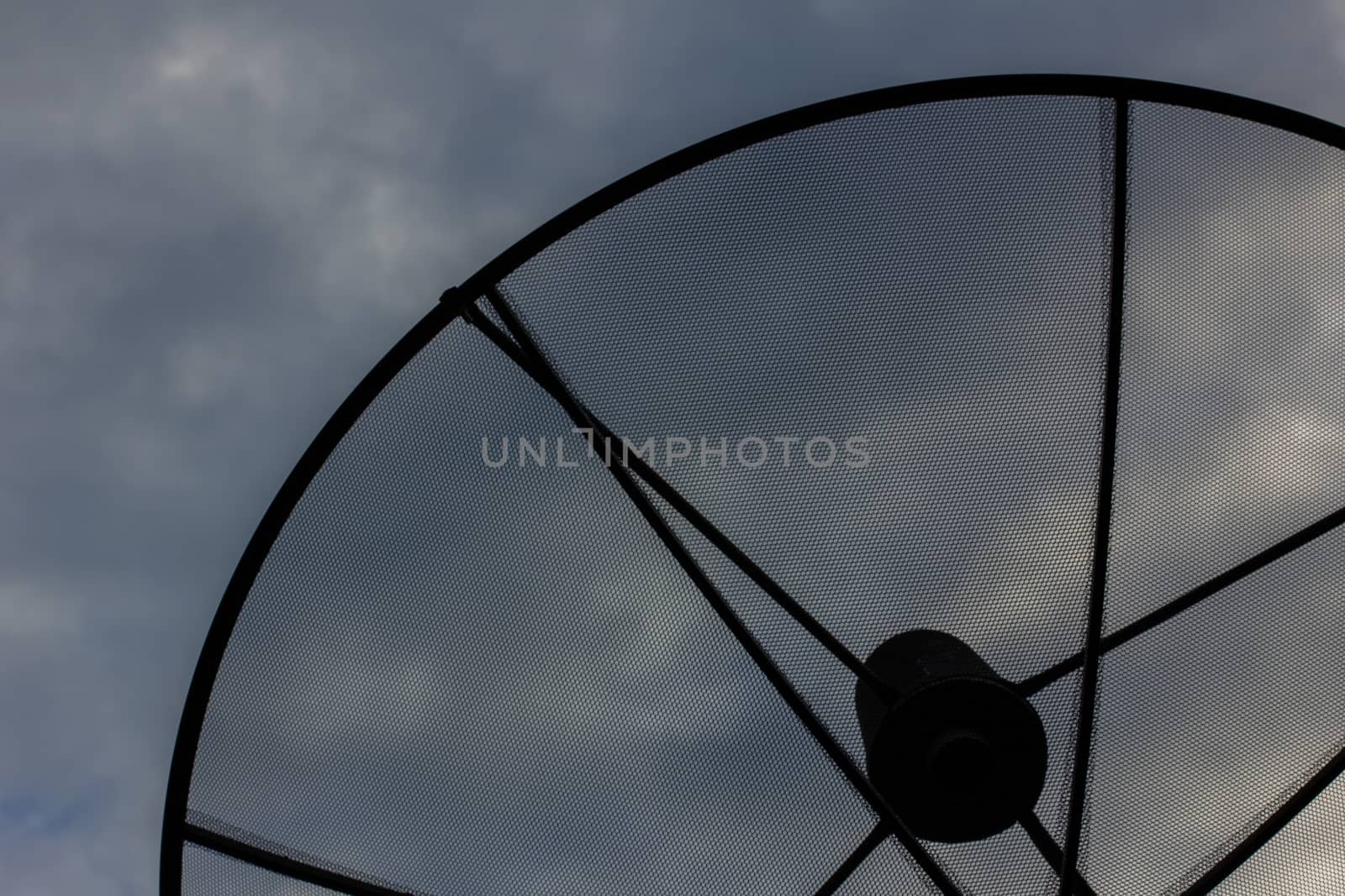 closeup of satellite dish in evening cloudy sky, silhouette.