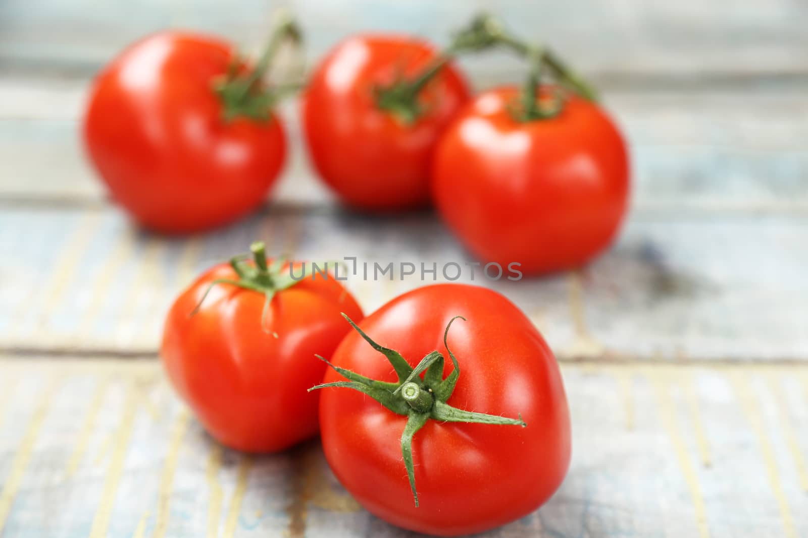 branch with fresh raw tomatoes on wooden background