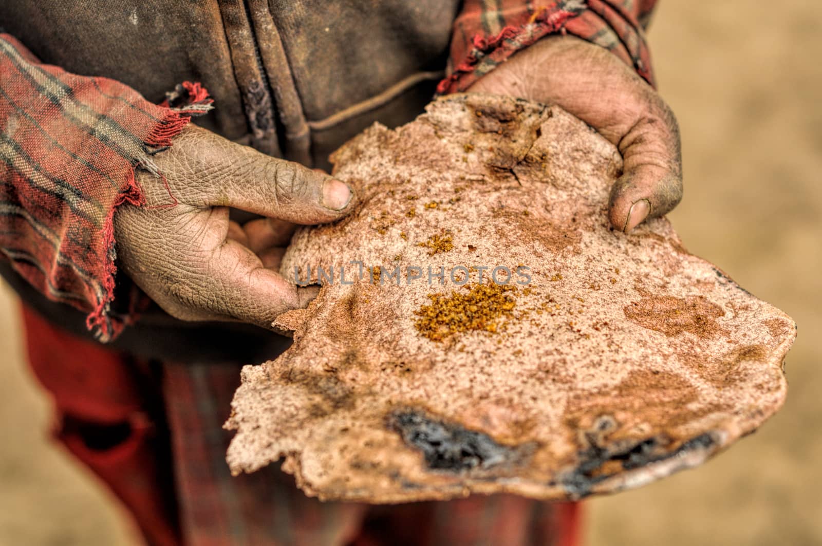 Traditional piece of thin nepalese bread in dirty hands